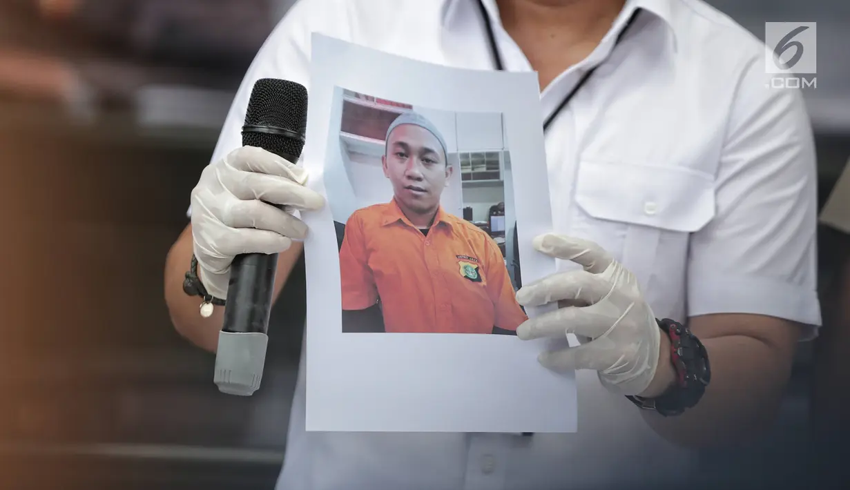 Polisi menunjukkan foto tersangka pengancam pemenggalan terhadap Presiden Joko Widodo atau Jokowi di Mainhall PMJ, Jakarta, Senin (13/5/2019). Di hadapan polisi, tersangka Hermawan Susanto mengaku khilaf dengan perbuatannya tersebut. (Liputan6.com/Faizal Fanani)