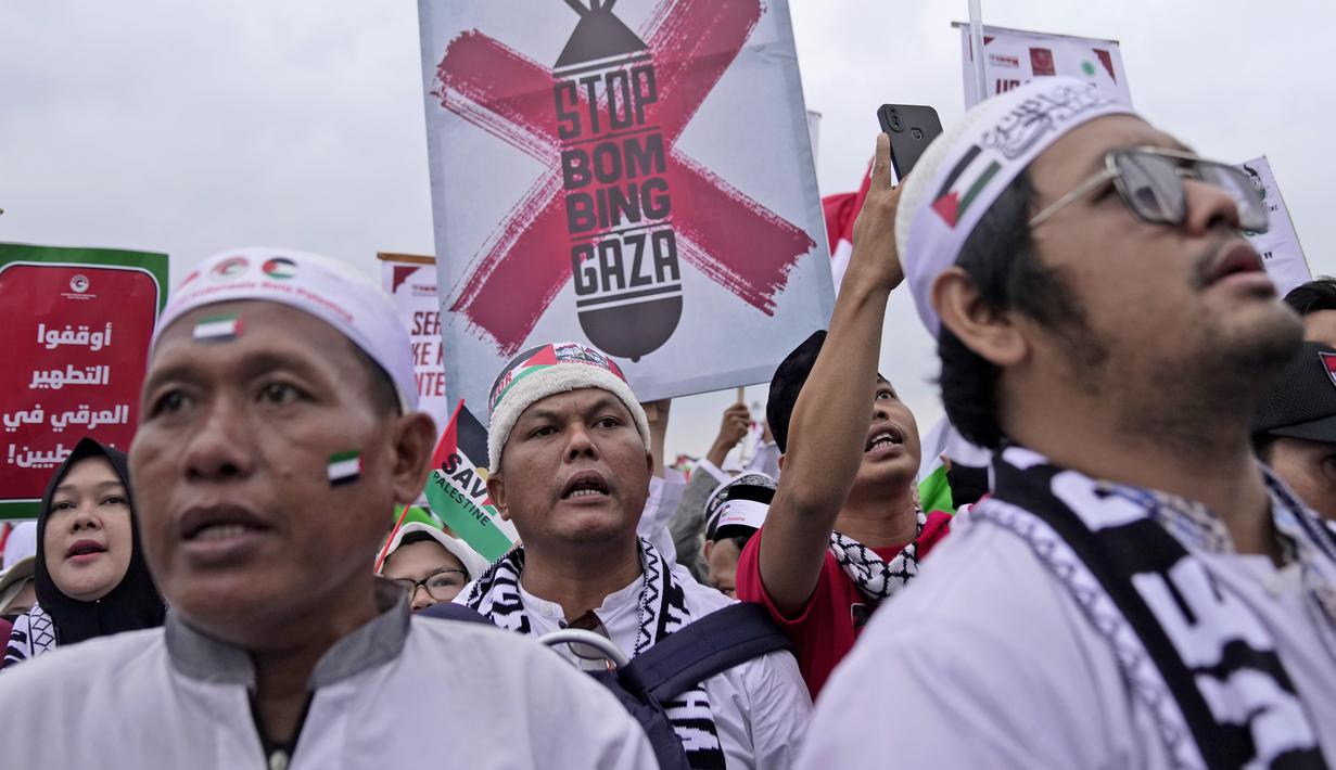 Terlihat massa aksi mengenakan pakaian serba putih dan hitam, dilengkapi berbagai atribut dengan warna selaras bendera Palestina. (AP Photo/Dita Alangkara)