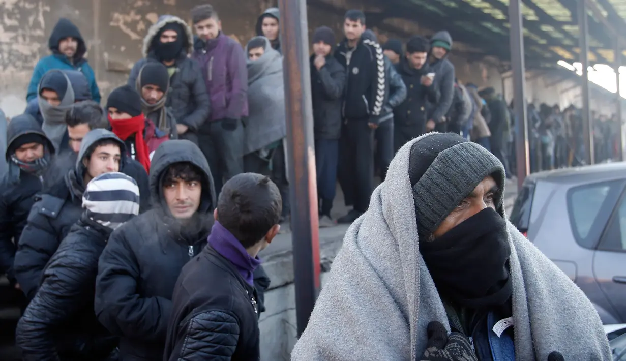 Sejumlah imigran mengantre panjang untuk mendapatkan makanan di depan sebuah gudang kosong di Belgrade, Serbia (8/1). Para imigran tersebut sebagian besar dari Afghanistan dan Pakistan. (AP Photo/Darko Vojinovic)