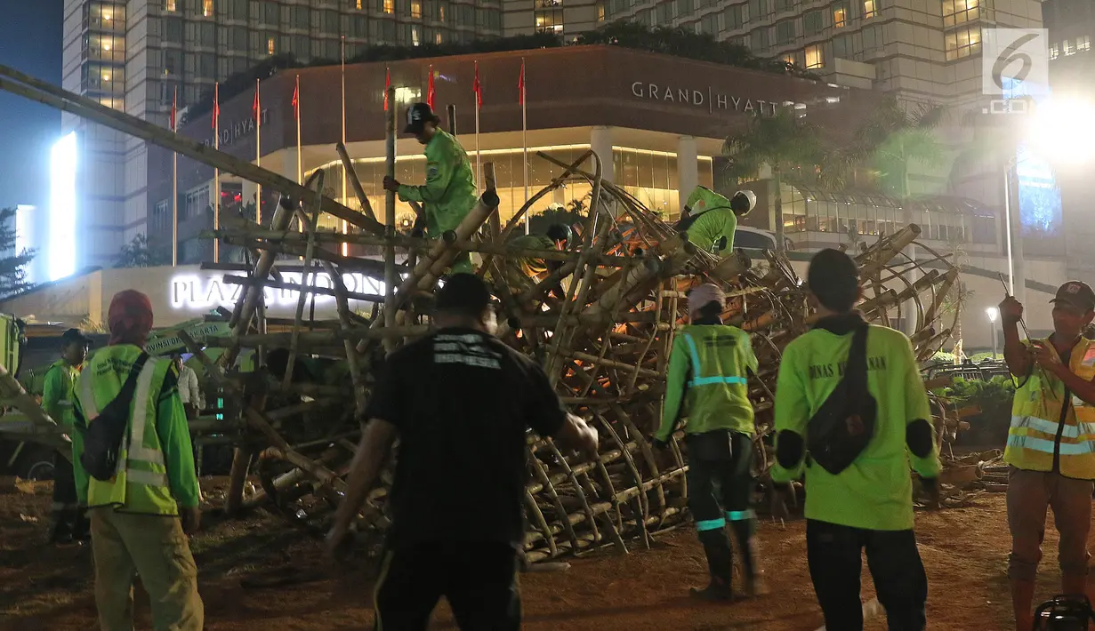 Aktivitas pembongkaran instalasi bambu Getah Getih di Bundaran Hotel Indonesia (HI), Jakarta, Kamis (18/7/2019) dini hari. Karya seni tersebut rencananya akan diganti dengan taman dan setelah dibongkar, bambu itu akan dibawa ke tempat pembuangan sampah. (Liputan6.com/Herman Zakharia)