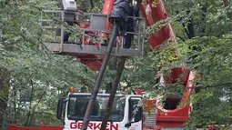 Polisi berusaha menangkap aktivis lingkungan di sebuah rumah pohon di hutan Hambacher Forst, Jerman Barat (13/9). Aktivis tersebut tinggal di rumah pohon untuk  melindungi hutan kuno dari razed untuk tambang batu bara di dekatnya. (Henning Kaiser/dpa/AFP)