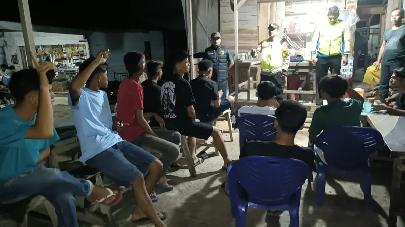 Personel Polres Rokan Hulu berbincang dengan pemuda mengajak rajin ronda jaga keamanan lingkungan.