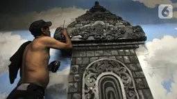 Joko menyelesaikan dekorasi panggung di Gedung Pertunjukan Wayang Orang Bharata, Jakarta, Kamis (7/11/2019). Joko bertugas untuk mempercantik properti seperti candi, bebatuan, dan pohon. (merdeka.com/Iqbal Nugroho)