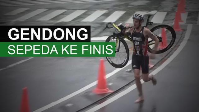 Peraih medali perak Olimpiade Rio 2016, Jonny Brownlee, menggendong sepedanya yang rusak untuk bisa finis dalam World Series Triathlon.