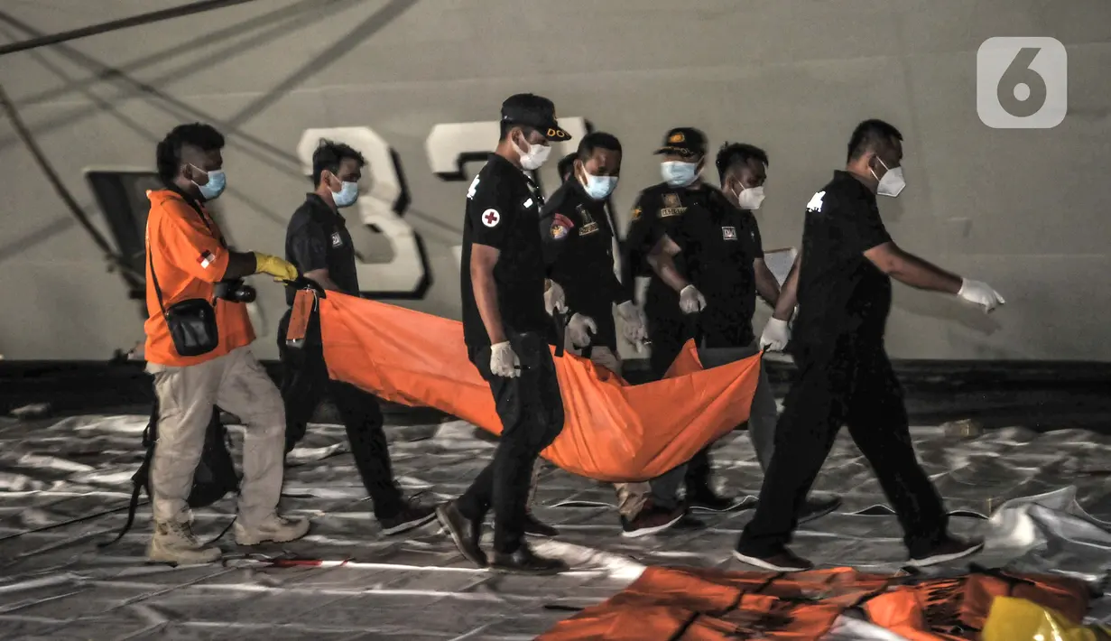 Tim DVI Polri membawa kantong jenazah berisi bagian tubuh korban kecelakaan Sriwijaya Air SJ 182 di Dermaga JICT 2, Tanjung Priok, Jakarta, Minggu (10/1/2021). Pencarian Sriwijaya Air SJ 182 dilakukan dengan mengerahkan kapal-kapal yang dilengkapi peralatan bawah laut. (merdeka.com/Iqbal S. Nugroho)
