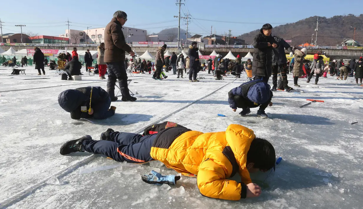 Peserta saat mengikuti lomba memancing ikan trout di sungai yang membeku di Hwacheon, Korea Selatan (6/1). Kontes ini merupakan bagian dari festival es tahunan yang menghasilkan lebih dari 1.000.000 pengunjung setiap tahunnya. (AP Photo/Ahn Young-joon)