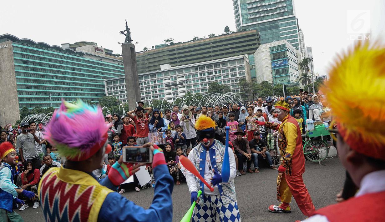 Aksi badut yang tergabung dalam Aku Badut Indonesia menghibur masyarakat saat car free day di Bunderan HI, Jakarta, Minggu (9/12). Aksi tersebut bentuk kampanye positif bertujuan mengajak masyarakat peduli terhadap sesama. (Liputan6.com/Faizal Fanani)