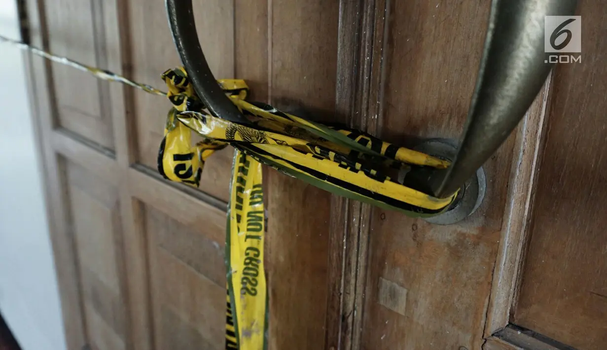 Petugas memasang garis polisi di pintu Gereja St Lidwina Bedog, Sleman, Yogyakarta, Minggu (11/2). (Liputan6.com/Arya Manggala)