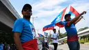 Warga melambaikan bendera Pakatan Harapan di sepanjang jalan menuju Istana Negara menjelang pelantikan Mahathir Mohamad sebagai PM Malaysia di Kuala Lumpur, Kamis (10/5). Mahathir akan menjadi perdana menteri ketujuh Negeri Jiran. (AFP/Manan VATSYAYANA)