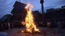 Para lelaki Nepal membakar patung jerami iblis Ghantakarna dalam festival Ghantakarna di kota kuno Bhaktapur, Nepal (30/7/2019). Festival Hindu ini juga dikenal dengan nama Gathemangal. (AFP Photo/Prakash Mathema)