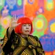 Seniman Jepang Yayoi Kusama melambaikan tangan dalam sesi pemotretan saat pratinjau pers pamerannya yang bertajuk "My Eternal Soul" di National Art Center, Tokyo, pada 21 Februari 2017. (TOSHIFUMI KITAMURA/AFP)