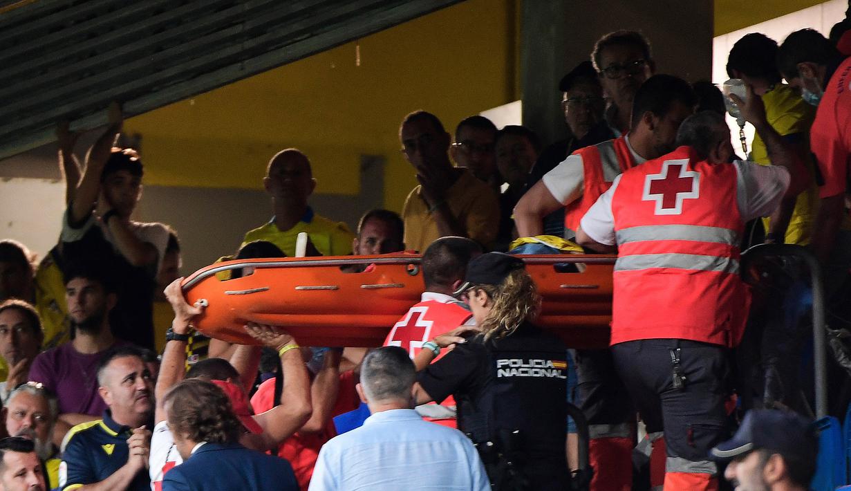 Tim medis akhirnya berhasil mengevakuasi penonton yang diduga mengalami serangan jantung tersebut keluar stadion untuk mendapatkan perawatan intensif. Kemudian pertandingan dilanjutkan setelah tertunda satu jam akibat insiden tersebut. (AFP/Cristina Quicler)