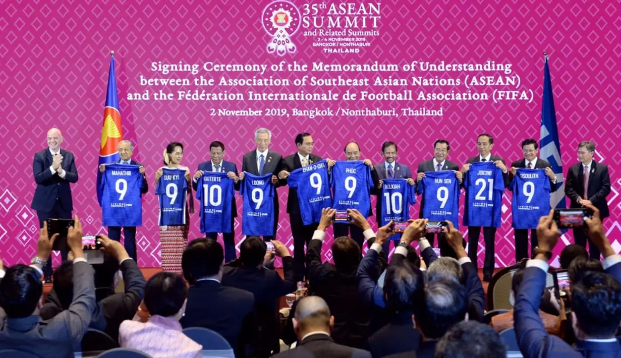 Presiden Jokowi bersama kepala negara dan kepala pemerintahan negara-negara ASEAN menunjukkan jersey bertuliskan nama masing-masing disaksikan Presiden FIFA Gianni Infantino (kiri) pada acara penandatanganan MoU antara ASEAN dengan FIFA di Bangkok, Sabtu (2/11/2019). (Liputan6.com/Biro Pers Setpres)