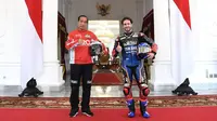 Presiden Joko Widodo berfoto dengan pembalap WithU Yamaha RNF MotoGP, Andrea Dovizioso di Istana Merdeka, Jakarta, Rabu (16/3/2022). Para pembalap datang dengan memakai setelah baju khusus balap motor yang akan dipakai dalam Grand Prix Indonesia di Mandalika. (Lukas - Biro Pers/Setpres)