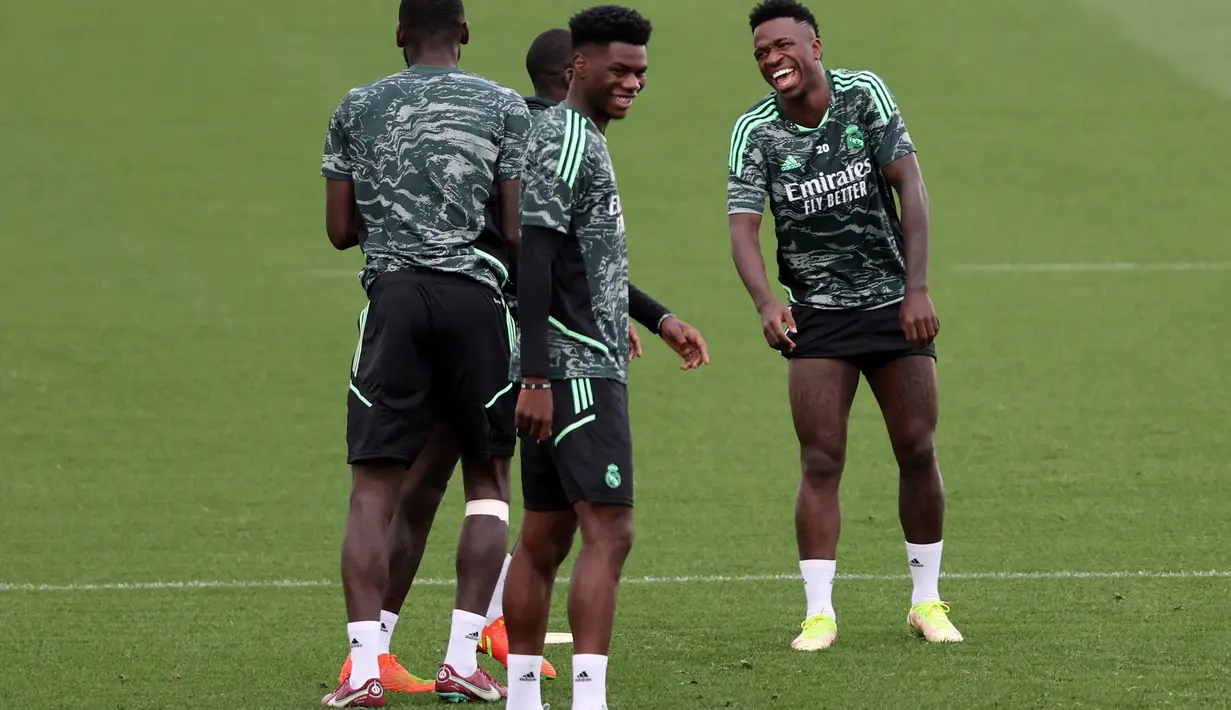 Gelandang Real Madrid, Aurélien Tchouaméni tertawa bersama rekan setimnya selama sesi latihan di kompleks latihan Ciudad Real Madrid di Valdebebas, pinggiran Madrid (13/9/2022). Real Madrid tentu ingin melanjutkan tren 100 persen kemenangan mereka musim ini di lintas ajang, termasuk saat menang di matchday 1 Grup F. (AFP/Thomas Coex)