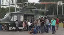 Warga mengerumuni helikopter TNI di kawasan Monumen Nasional, Jakarta, Jumat (19/4). Libur panjang perayaan Paskah 2019 dimanfaatkan warga untuk berwisata di kawasan Monumen Nasional. (Liputan6.com/Helmi Fithriansyah)