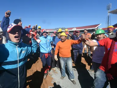 Suporter klub sepakbola Cerro Porteno saat menyelesaikan pembangunan stadion baru di Asuncion, Paraguay (22/6). Cintanya dengan tim ini, puluhan suporter ini membantu menyelesaikan pembangunan stadion tersebut. (AFP Photo/Norberto Duarte)