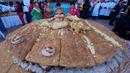 Cholitas berpose untuk foto selama presentasi "sandwich de chola" raksasa, di La Paz, Bolivia, Selasa, 2 Juli 2024. (AP Photo/Juan Karita)