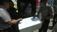 Anggota kepolisian mengangkat kotak berisikan potongan tubuh yang diduga korban jatuhnya pesawat M28 Skytruck milik Polri di Pelabuhan Telaga Punggur, Batam, Kepulauan Riau, Minggu (4/12). Pesawat itu membawa 5 kru dan 8 penumpang. (SEI RATIFA/AFP)