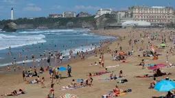 Orang-orang berjemur di pantai Port Vieux, (Old Seaport) di Biarritz, barat daya Prancis, (19/4). Suhu di Prancis barat daya telah mencapai 27 derajat Celcius (80,6 Fahrenheit). (AP Photo / Bob Edme)