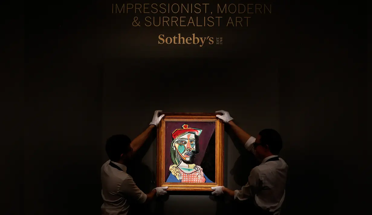 Petugas rumah lelang Sotheby menata lukisan Pablo Picasso bertema Marie-Therese Walter di London, Rabu (22/2). Dari semua gaya dan dekade artis, inilah salah satu yang paling melambangkan warisan Picasso sebagai potret wanita. (AP/Frank Augstein)