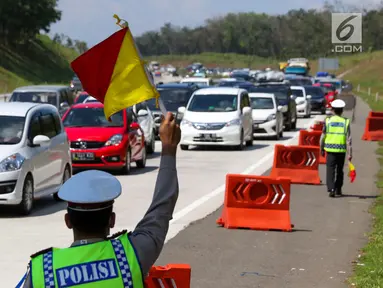 Petugas kepolisian mengatur lalu lintas di jalur arah Jakarta Tol Cipali, Jawa Barat, Kamis (29/6). Sejumlah kepolisian disiagakan untuk mengatur lalu lintas di Tol Cipali yang semakin padat oleh pemudik arus balik. (Liputan6.com/Faizal Fanani)