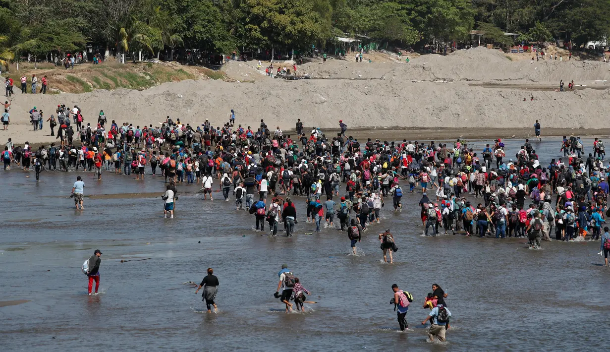 Migran Amerika Tengah menyeberangi Sungai Suchiate dengan berjalan kaki dari Guatemala ke Meksiko, Tecun Uman, Guatemala, Senin (20/1/2020). Lebih dari seribu migran Amerika Tengah yang terdampar di Guatemala berjalan massal untuk menuju Amerika Serikat. (AP Photo/Moises Castillo)