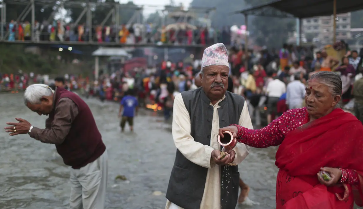 Umat Hindu Nepal melakukan ritual di sungai Bagmati selama festival Kuse aunsi di Kathmandu, Jumat (30/8/2019). Kuse Aunsi merupakan bentuk perayaan Hari Ayah bagi masyarakat Nepal.  (AP Photo/Niranjan Shrestha)
