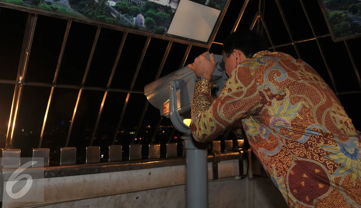 Gubernur DKI Jakarta Basuki Tjahaja Purnama (Ahok) melihat Jakarta dari puncak Monas usai meresmikan Wisata Malam Monas di Jakarta, Selasa (5/4). (Liputan6.com/Gempur M Surya)