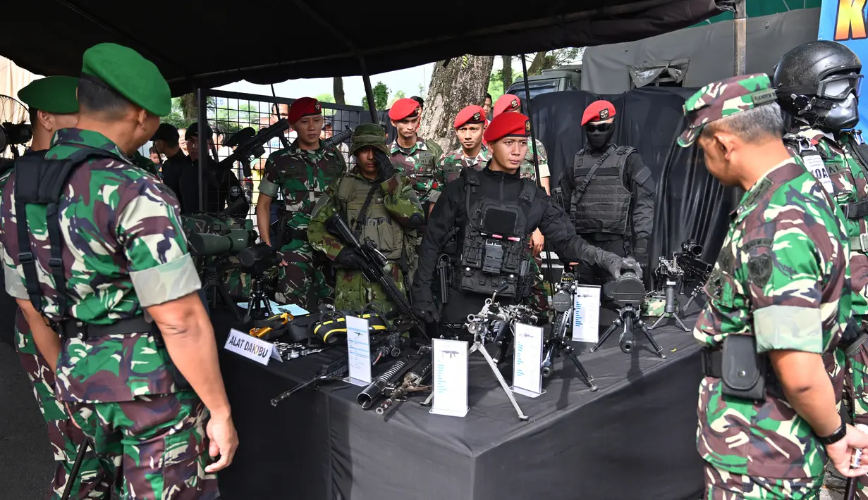 Tentara memperlihatkan jenis-jenis senjata saat apel pengamanan Pemilu 2019 di Bogor, Jawa Barat, Rabu (10/4). Apel dihadiri Panglima TNI Marsekal Hadi Tjahjanto dan Kapolri Jenderal Tito Karnavian. (ADEK BERRY/AFP)