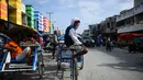 Tukang becak menunggu penumpang di sebuah psaar tradisional usai gempa dan tsunami melanda Palu, Sulawesi Tengah, Kamis (4/10). (Permata SAMAD/AFP)