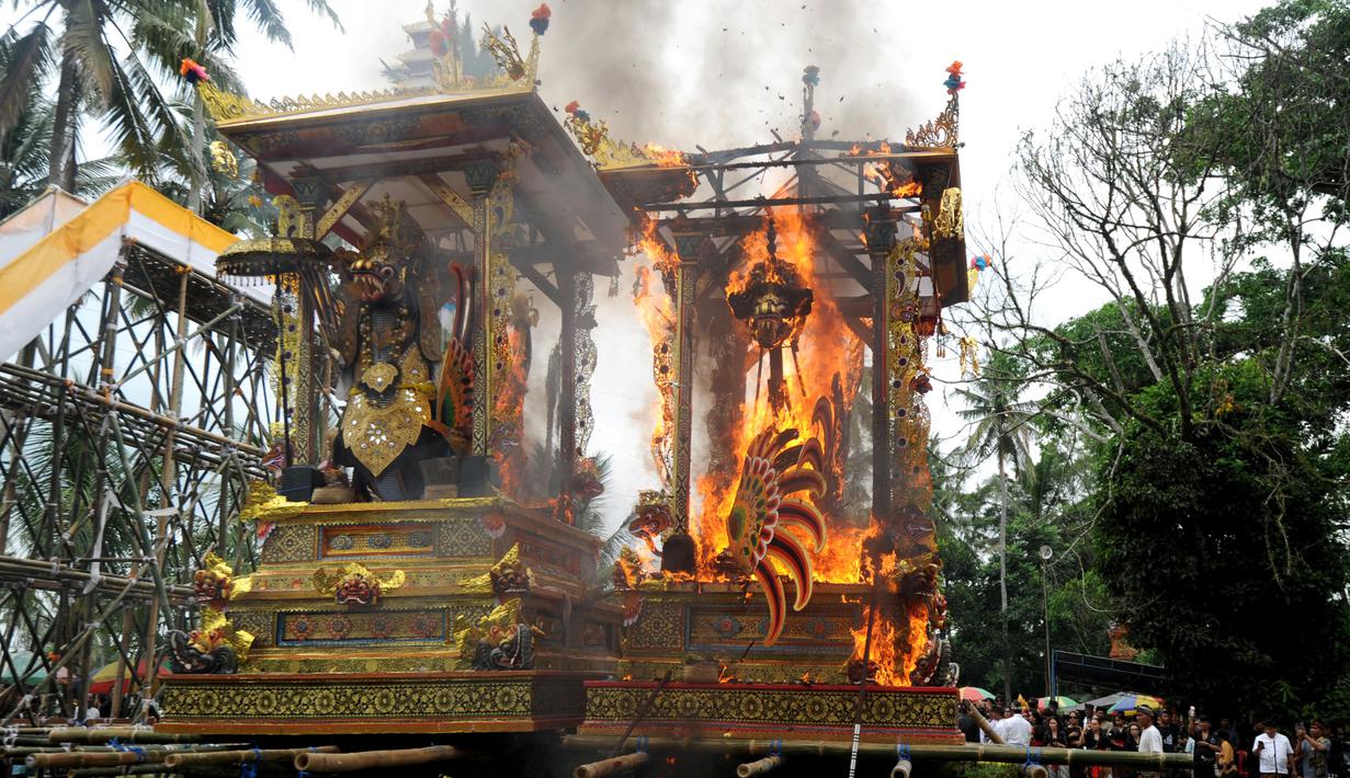 Peti berbentuk naga yang berisi jenazah anggota keluarga dari pahlawan nasional I Gusti Ngurah Rai dibakar dalam prosesi upacara Ngaben di Desa Carangsari, Bali, Senin (29/4/2019). Ribuan waga mengiringi kremasi terhadap jenazah putra kedua dan cucu dari I Gusti Ngurah Rai itu. (SONNY TUMBELAKA/AFP)