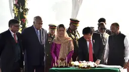 Presiden Joko Widodo dan Ibu Negara Iriana Joko Widodo mengisi buku tamu di National Martyrs’ Memorial, Bangladesh (28/1).  Jokowi dan Ibu Iriana melanjutkan perjalanan menuju Bangabhandu Memorial Museum. (Liputan6.com/Pool/Rusman Biro Pers Setpres)