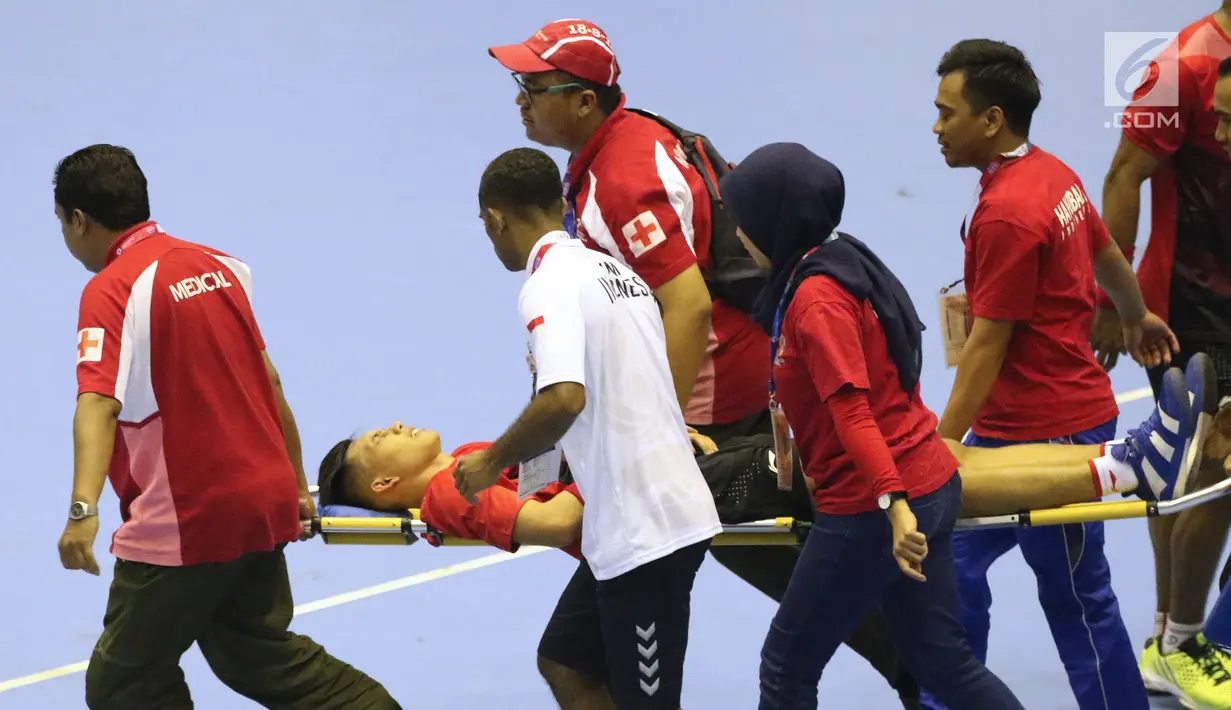 Petugas medis mengevakuasi pemain bola tangan Indonesia, Andi Yoga Ananda saat laga melawan Malaysia pada penyisihan grup 3 bola tangan Asian Games 2018 di GOR PP POPKI, Jakarta, Minggu (26/8). Indonesia unggul 31-22. (Liputan6.com/Helmi Fithriansyah)