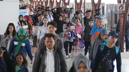 Penumpang membawa barang mereka usai turun dari kereta api jurusan Jawa Tengah tiba di Stasiun Senen, Jakarta, Rabu (28/6). (Liputan6.com/Angga Yuniar)