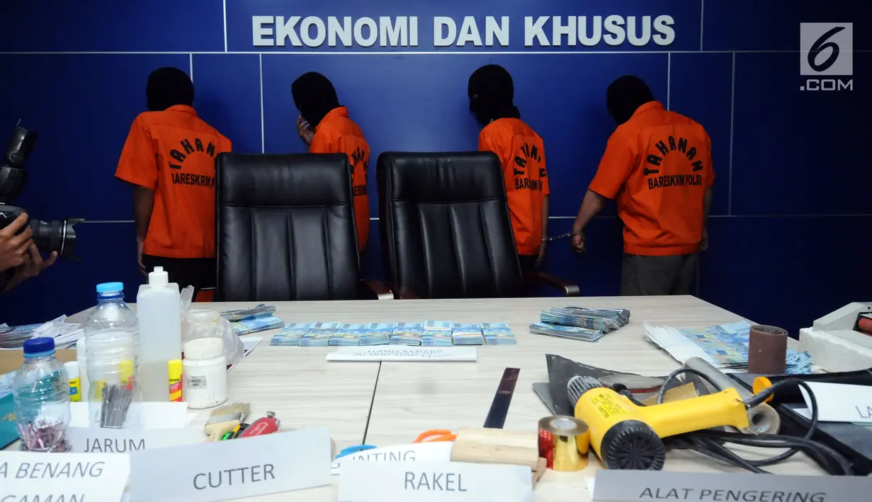 Empat tersangka peredaran uang palsu berikut barang bukti diperlihatkan saat rilis di Bareskrim Polri, Jakarta, Senin (29/1). Dirtidpid Ekonomi dan Khusus Bareskrim Polri menangkap empat tersangka di wilayah Cikarang. (Liputan6.com/Helmi Fithriansyah)