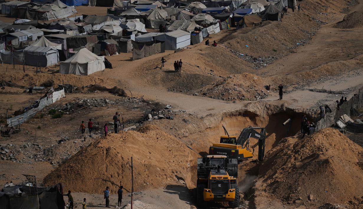 Aktivitas pekerja Mesir yang menggunakan alat berat untuk mencari jenazah para sandera di Kota Hamad, Khan Younis, di Jalur Gaza selatan, Selasa 28 Oktober 2025. Kondisi reruntuhan yang masif akibat dua tahun serangan Israel, serta jaringan terowongan Hamas, membuat proses pencarian jenazah menjadi sangat sulit. (AP Photo/Abdel Kareem Hana)