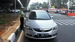 Polisi memberikan surat tilang kepada pengemudi mobil berpelat nomor genap di Jalan MT Haryono, Jakarta, Rabu (1/8). Polisi hari ini mulai memberlakukan sanksi tilang kepada pelanggar aturan di kawasan perluasan ganjil genap (Merdeka.com/Iqbal S. Nugroho)