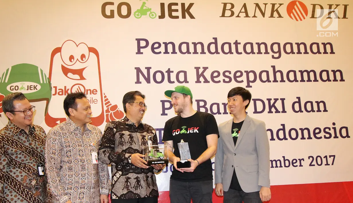 Direktur Bisnis Bank DKI,  Antonius Widodo Mulyono (tengah) dan CMO Go-Jek,  Piotr Jakubowski (kedua kanan) saat berbincang usai MoU interoperabilitas uang elektronik dan perluasan channel pembayaran pajak, Selasa (7/11). (Liputan6.com/Pool/Budi)