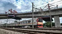 Kereta Commuter Line melintas di bawah proyek pembangunan jalur lintas atas (flyover) Cakung, Jakarta, Kamis (17/12/2020). Proyek Flyover Cakung saat ini telah mencapai 94 persen dan sedang menyelesaikan pemasangan balok girder pada bentang yang melintasi rel kereta api. (merdeka.com/Iqbal Nugroho)