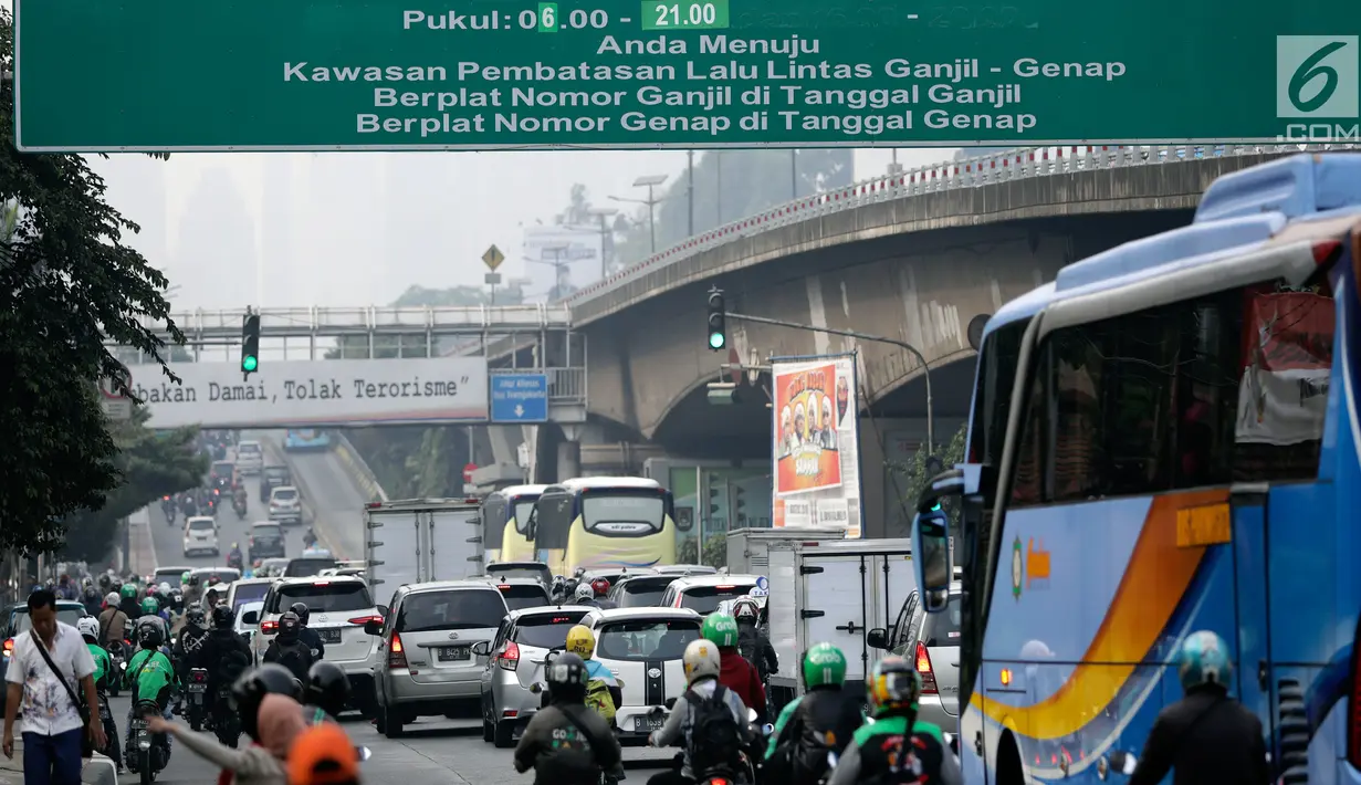 Kendaraan melintas di bawah papan informasi sistem ganjil genap di Jalan S Parman, Jakarta, Rabu (1/8). Pemprov DKI hari ini resmi memberlakukan sistem ganjil genap dengan memberikan sanksi tilang bagi pengendara yang melanggar. (Liputan6.com/Johan Tallo)