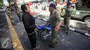 Petugas Satpol PP berdiskusi dengan seorang yang terkena razia yang parkir di kawasan pendestrian Malioboro, (19/4). Petugas memberikan surat peringatan dan mengambil kartu identitasnya yang di tahan di KUPT Malioboro. (Liputan6.com/Boy Harjanto)