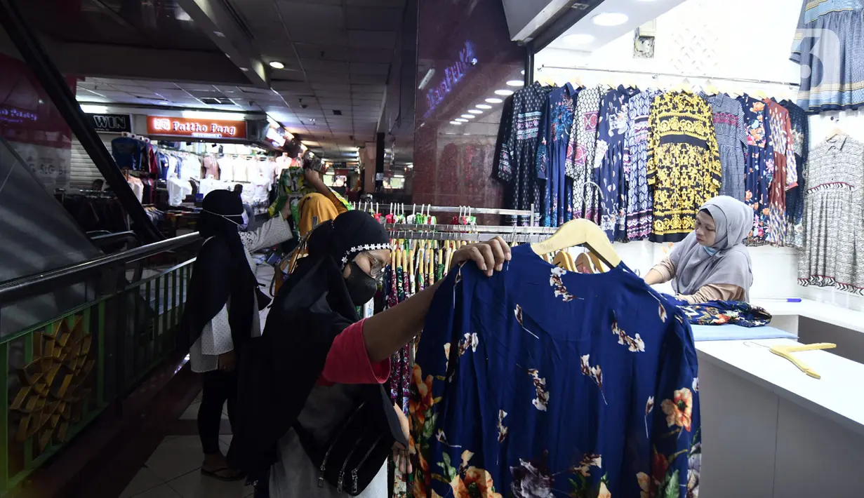 Pengunjung memilih baju di Pasar Tanah Abang Blok A, Jakarta, Rabu (19/5/2021). Pada hari ini, Pasar Tanah Abang kembali dibuka setelah ditutup sementara selama sepekan pada 12-18 Mei 2021. (Liputan6.com/Herman Zakharia)