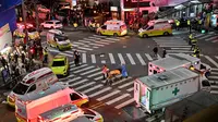 Seseorang, yang diyakini menderita serangan jantung, diangkut dengan tandu di distrik kehidupan malam populer Itaewon di Seoul, Korea Selatan, Minggu (30/10/2022). Lebih dari 140 ambulans dikerahkan ke tempat kejadian untuk membantu mengevakuasi para korban tragedi Halloween Itaewon. (Photo by JUNG YEON-JE / AFP)