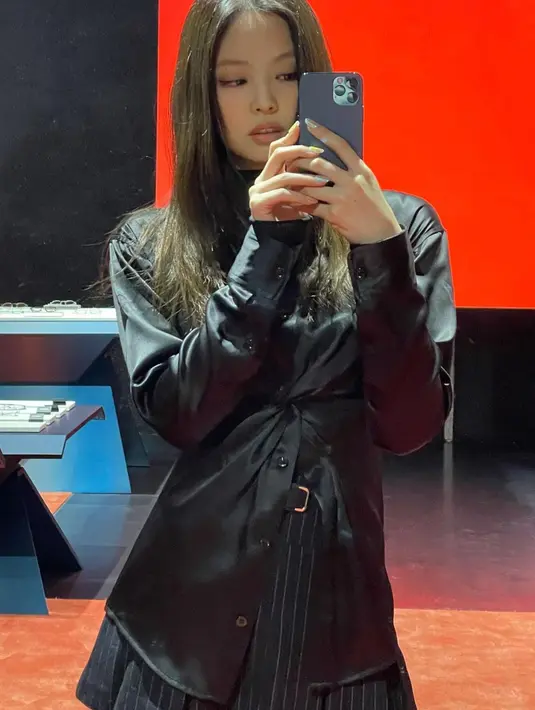 <p>Jennie berpose saat pemotretan sebuah brand pakaian. Jennie menggunakan kemeja berwarna hitam dan rok pendek dengan warna senada. (Instagram/@jennierubyjane)</p>