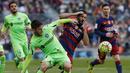 Gelandang Barcelona, Arda Turan, berebut  bola dengan gelandang Getafe, Alvaro Medran. Sementara bagi Getafe kekalahan ini membuat mereka terpuruk ke posisi 17, setinggat di atas zona degragasi. (Reuters/Albert Gea)