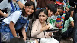 Jessica Mila berpose bersama penggemarnya di sela-sela syuting sinetron Ganteng-Ganteng Serigala di kawasan Buperta Cibubur, Jakarta, Rabu (22/7/2015). (Liputan6.com/Panji Diksana)