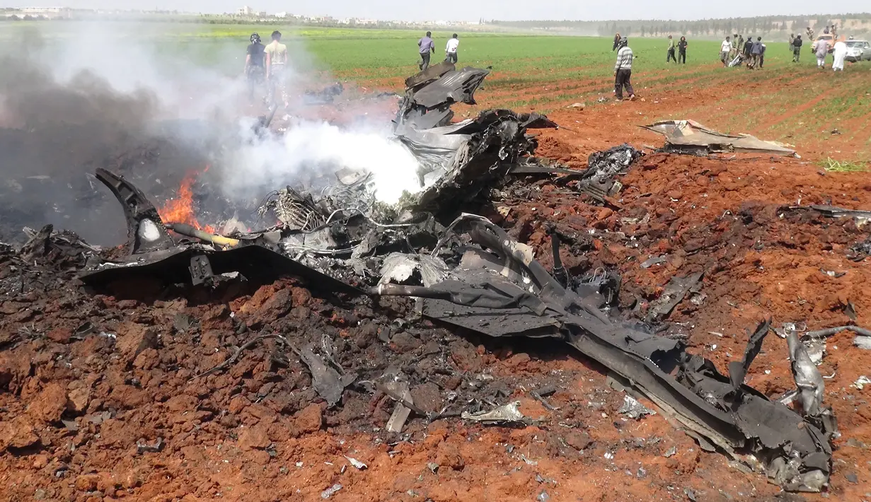 Api terlihat di puing pesawat Su-22 milik Angkatan Udara Suriah yang ditembak jatuh di wilayah selatan Aleppo, Selasa (5/4). Sayap kelompok teroris Al-Qaeda di Suriah, Front al-Nusra, menembak jatuh jet SU-22 itu menggunakan roket. (OMAR HAJ KADOUR/AFP)