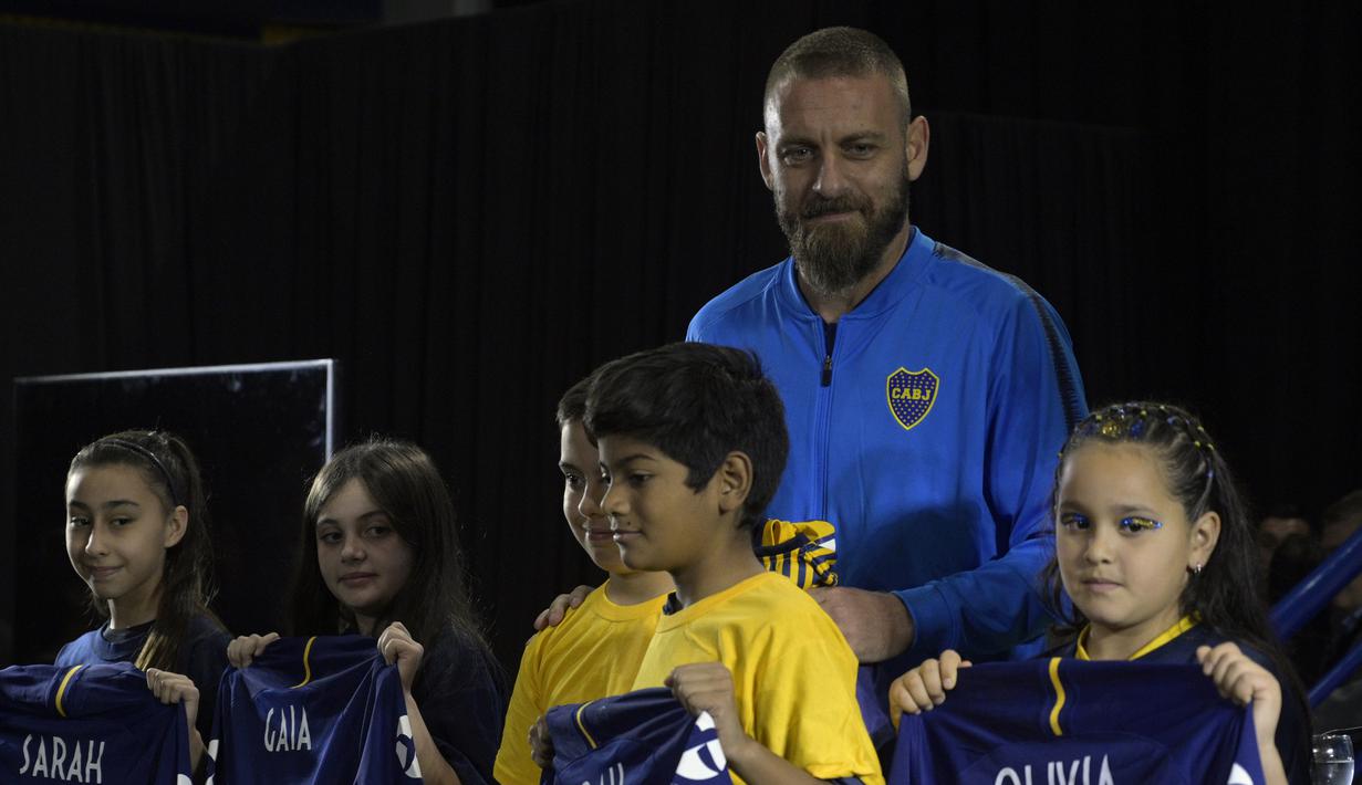 Gelandang baru Boca Juniors, Daniele De Rossi foto bersama anak-anak selama pengenalan dirinya di Buenos Aires, Argentina (29/7/2019). De Rossi yang 36 tahun mengakhiri 18 tahun karirnya di Roma akhir musim lalu. (AFP Photo/Juan Mabromata)