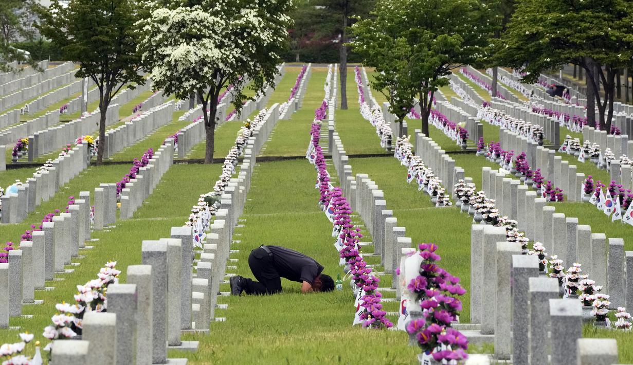 Warga Korea Selatan Park Ung-gi membungkuk di depan nisan pamannya Park Tae-son yang gugur saat Perang Korea pada peringatan Hari Pahlawan di Pemakaman Nasional Seoul, Seoul, Korea Selatan, Senin (6/6/2022). (AP Photo /Ahn Young-joon)